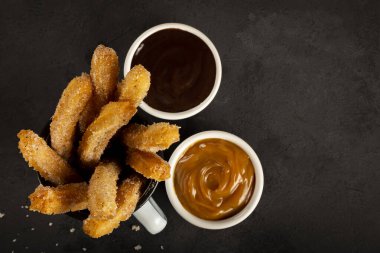 Sugary churros with dulce de leche. clipart