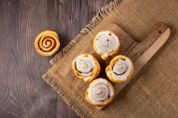 Cinnamon rolls on wooden background.