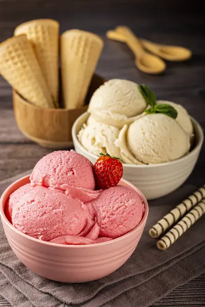 Bowls with strawberry and vanilla ice cream.