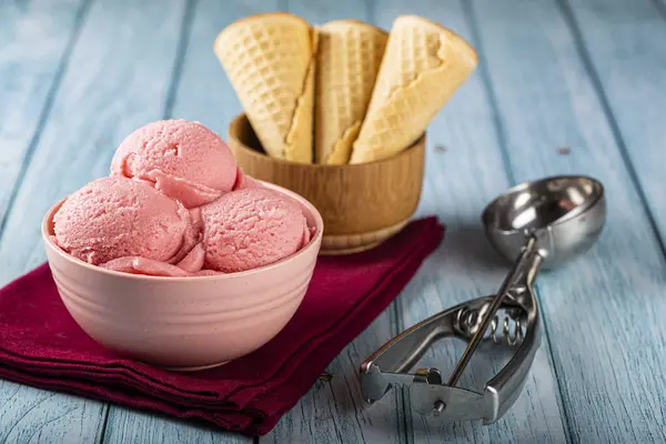 Bowl with strawberry ice cream balls.