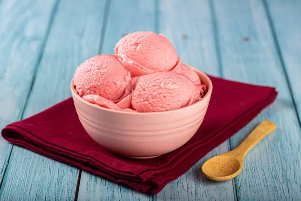 Bowl with strawberry ice cream balls.