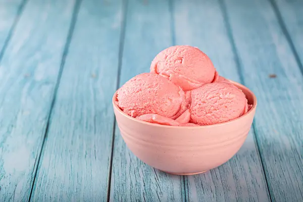 Bowl with strawberry ice cream balls.