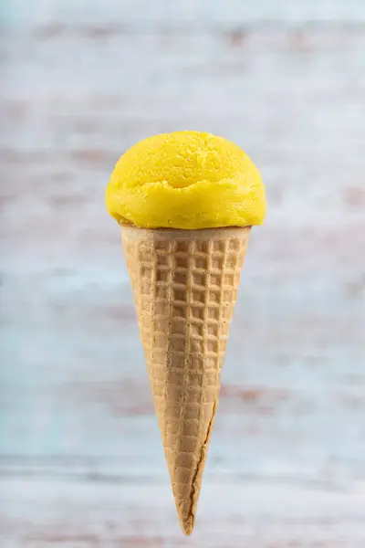 Tasty pineapple flavored ice cream cone.