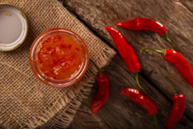 Masanın üzerinde cam kavanozda biber jölesi.