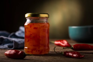 Masanın üzerinde cam kavanozda biber jölesi.