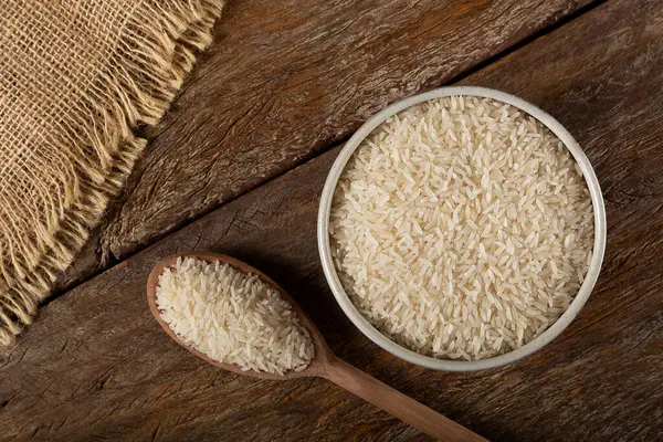 Kahverengi Ahşap Arka Planda Seramik Bir Kasede Çiğ Beyaz Pirinç — Stok fotoğraf