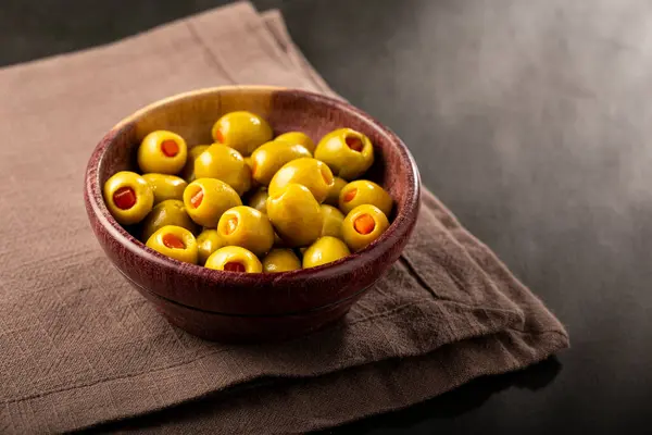 Stuffed green olives in a bowl.