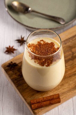 Tarçın tozlu eggnog bardağı.