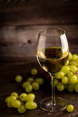 Masanın üzerinde bir bardak beyaz şarap..