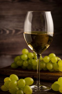 Masanın üzerinde bir bardak beyaz şarap..