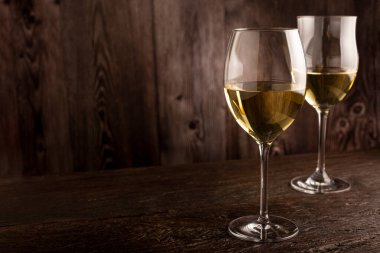 Masanın üzerinde bir bardak beyaz şarap..