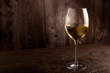 Masanın üzerinde bir bardak beyaz şarap..