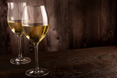 Masanın üzerinde bir bardak beyaz şarap..