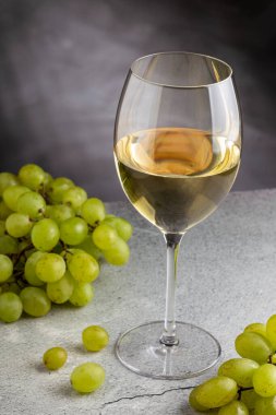 Masanın üzerinde bir bardak beyaz şarap..