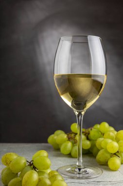 Masanın üzerinde bir bardak beyaz şarap..