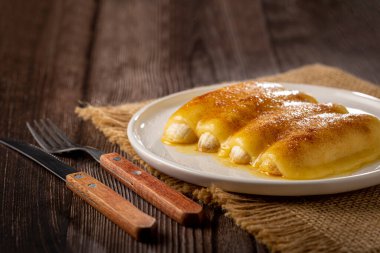 Brezilya 'nın kuzeydoğusunda geleneksel tatlı, Cartola ya da silindir şapkalı tatlı olarak bilinir..