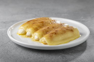 Brezilya 'nın kuzeydoğusunda geleneksel tatlı, Cartola ya da silindir şapkalı tatlı olarak bilinir..