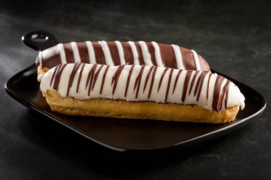 Eclair. Lezzetli çikolatalı ekler masada..