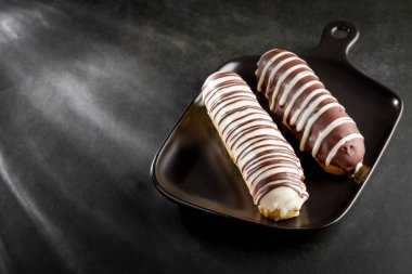 Eclair. Lezzetli çikolatalı ekler masada..