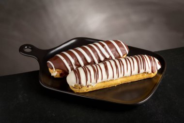 Eclair. Lezzetli çikolatalı ekler masada..