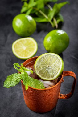 Masanın üzerinde bakır bardakta Moskova katırı kokteyli.