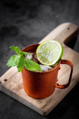 Masanın üzerinde bakır bardakta Moskova katırı kokteyli.