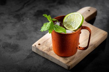 Masanın üzerinde bakır bardakta Moskova katırı kokteyli.