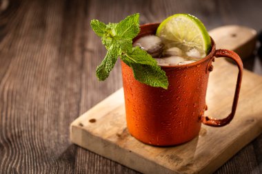 Masanın üzerinde bakır bardakta Moskova katırı kokteyli.