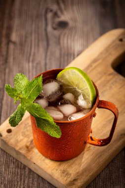 Masanın üzerinde bakır bardakta Moskova katırı kokteyli.