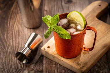 Masanın üzerinde bakır bardakta Moskova katırı kokteyli.