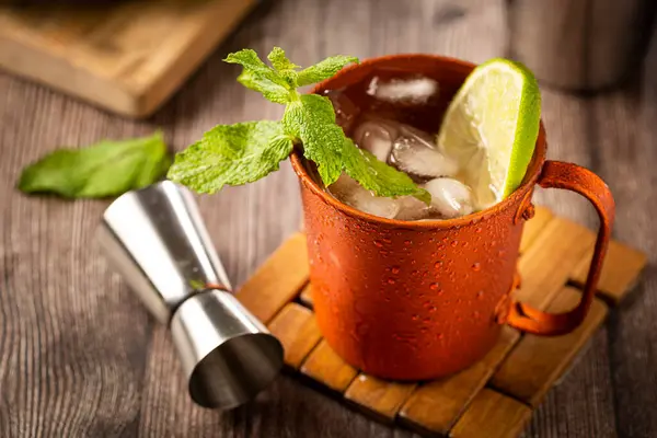 Moscow mule cocktail in copper mug on the table.