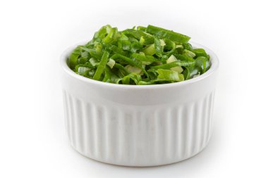 Beyaz arkaplanda ramekin dilimlenmiş soğan.