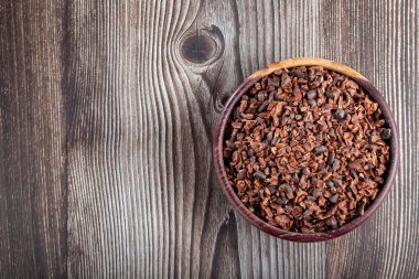 Masanın üzerinde kakao parçaları olan bir kase..