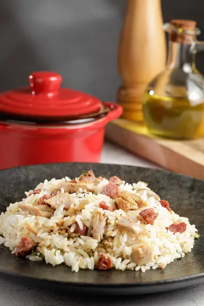 Rice dish with pieces of shank and bacon.