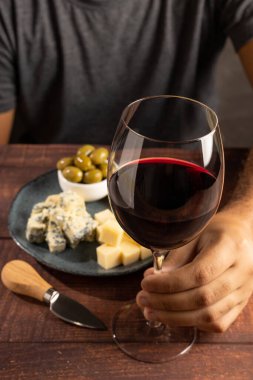 Şarap ve peynir tatan bir adam..