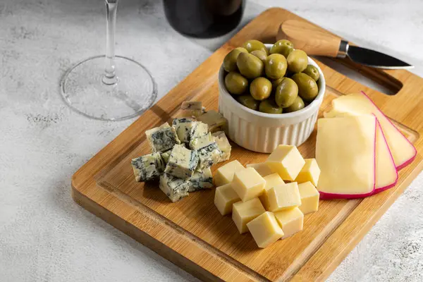 ワインのグラスと異なるチーズのプレート チーズボード — ストック写真