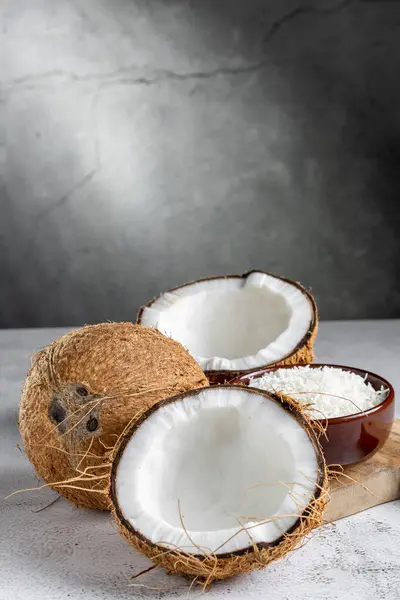 Whole coconut and pieces of coconut on the table.
