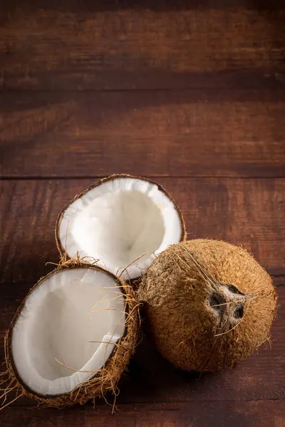 Whole coconut and pieces of coconut on the table.