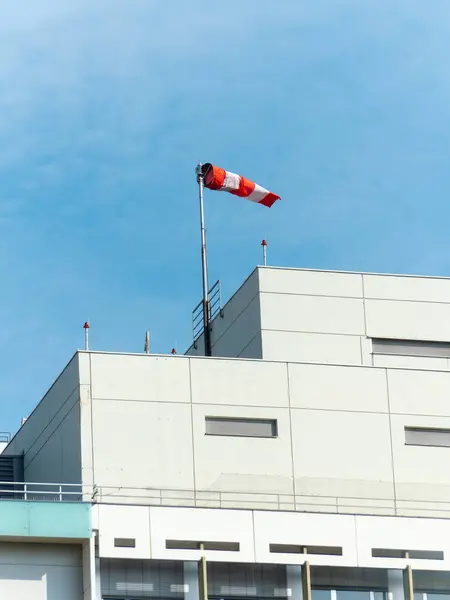A windsock is a visual wind direction indicator on the top of the building