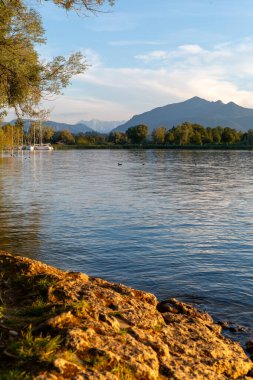 Bavyera 'daki Chiemseestrand sahillerinde güzel bir akşam. Sakin göl, renkli gökyüzü ve mükemmel hava inanılmaz bir atmosfer yaratır..