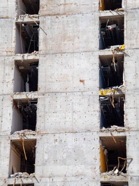 İşçiler, yüksek binaların yıkıldığı bir inşaat sahasının etrafında manevra yapıyorlar..