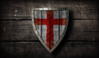 Eski ahşap arka planda gümüş kaplama ve kırmızı beyaz İngiliz desenli ortaçağ ahşap ahşap kalkanı.