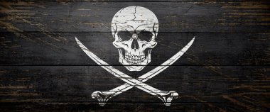 Korsan kafatası ve kemik bayrağı eskimiş siyah boyalı eski gemi tahtalarında