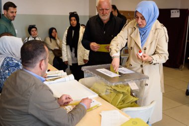 İstanbul, Türkiye, 14 Mayıs 2023 Saffet ebi okulundaki genel seçimlerde genç bir kadının oy kullandığı görülüyor. 64 milyon Türk vatandaşı oy kullanmak için sandık başına çağrıldı.