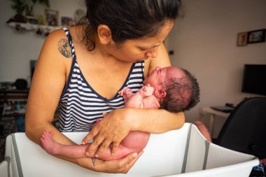Genç anne evde yeni doğan kızına ilk banyosunu yapıyor. Aile ve annelik kavramının yakınlığı ve bakımı..
