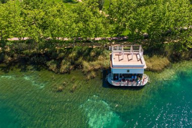 Girona, Katalonya, İspanya 'da balıkçı kulübesi olan Banyoles Gölü' nün havadan görünüşü. Sabahları huzurlu göl manzarası ve alacakaranlıkta sıcak bir ışıkla çekilen İHA çekimi.