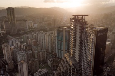 Gün batımında Caracas 'ın gökdelen ve gecekondu manzarası görülebilir. Gün batımında Venezuela başkentinin insansız hava aracı çekimi. Gelişmekte olan bir ülkede kalkınma kavramı