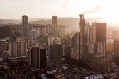 Gün batımında Caracas 'ın gökdelen ve gecekondu manzarası görülebilir. Gün batımında Venezuela başkentinin insansız hava aracı çekimi. Gelişmekte olan bir ülkede kalkınma kavramı