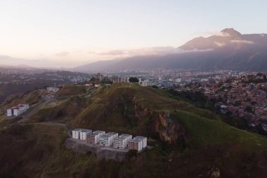 Aerial view of Caracas at sunset with the Petare neighborhood, the largest slum in Venezuela and latin america, with the Avila Mountain in the background. clipart