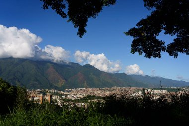 Günbatımında Venezuela ve Latin Amerika 'nın en büyük gecekondu mahallesi olan Petare Mahallesi ile Avila Dağı' nın arka planında hava manzarası.